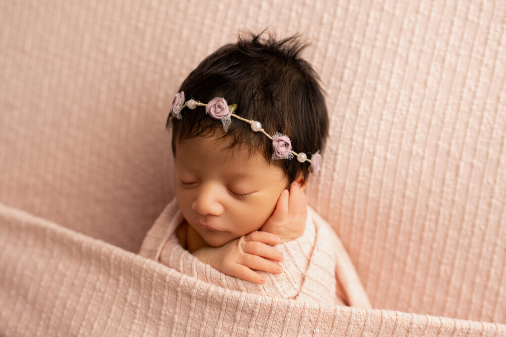 beautiful baby girl newborn session with soft pastel pink, floral headback, wrapped