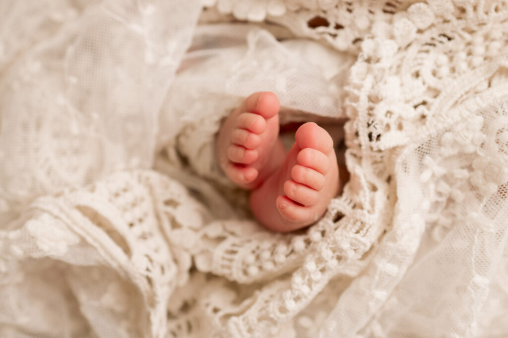 newborn baby girl toes wrapped with lace wrap